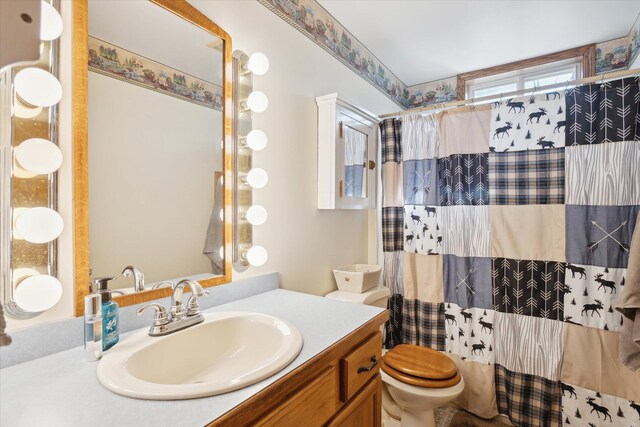 bathroom with walk in shower, vanity, and toilet