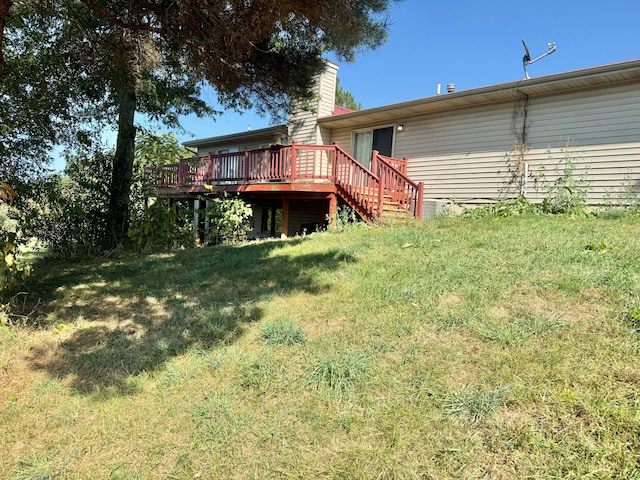 back of house featuring a lawn and a deck