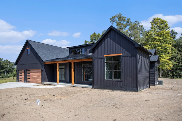 modern farmhouse with covered porch, central AC, and a garage