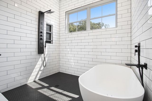 bathroom with tiled shower, a soaking tub, and tile walls