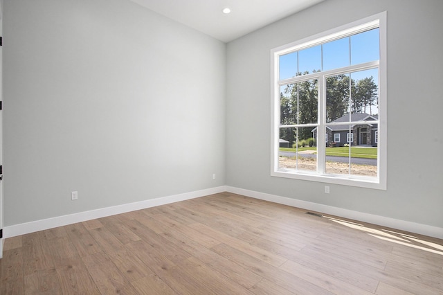 spare room with recessed lighting, light wood-style flooring, and baseboards