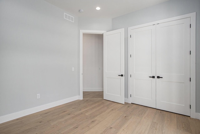 unfurnished bedroom with visible vents, recessed lighting, a closet, light wood-style floors, and baseboards