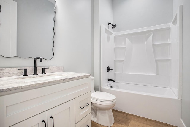 full bath featuring vanity, bathing tub / shower combination, toilet, and wood finished floors