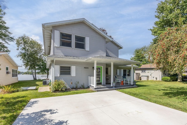 view of front of home with central air condition unit, a front yard, and covered porch