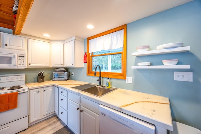 kitchen with white appliances, light hardwood / wood-style floors, white cabinetry, sink, and beam ceiling