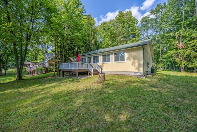 view of front of property featuring crawl space, a wooden deck, and a front lawn