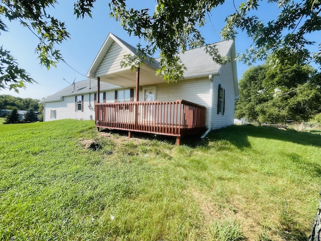 rear view of property with a yard and a wooden deck