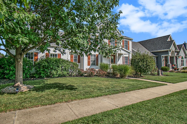 obstructed view of property with a front lawn