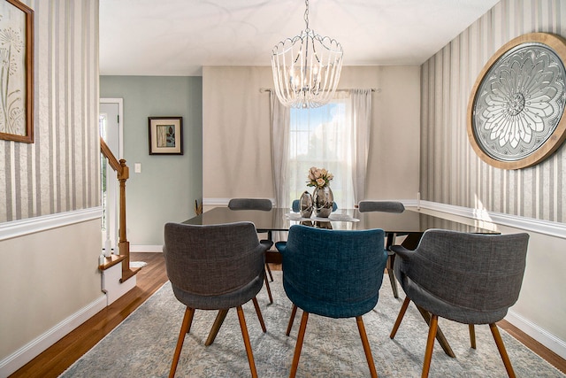 dining space featuring wood-type flooring and a chandelier