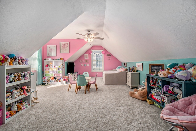 recreation room featuring lofted ceiling, carpet flooring, ceiling fan, and a textured ceiling