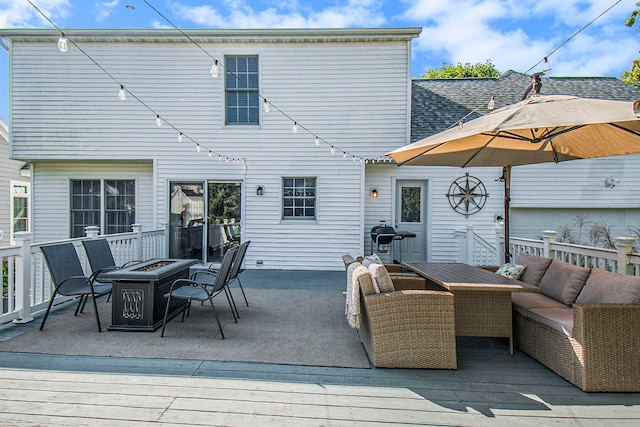 back of property featuring a wooden deck and an outdoor fire pit