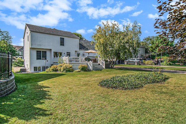 rear view of house with a yard and central AC unit