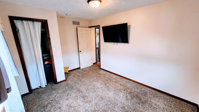 unfurnished bedroom featuring a textured ceiling and carpet floors