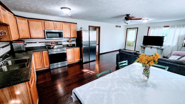 kitchen featuring backsplash, stainless steel appliances, dark hardwood / wood-style flooring, sink, and ceiling fan