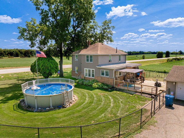 view of swimming pool with a wooden deck and a yard