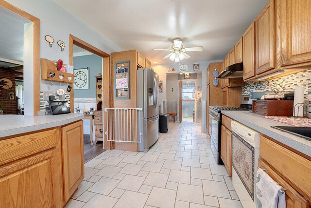 kitchen with backsplash, stainless steel refrigerator with ice dispenser, dishwasher, ceiling fan, and gas range oven