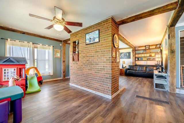 interior space with ceiling fan, dark hardwood / wood-style flooring, beamed ceiling, and ornamental molding