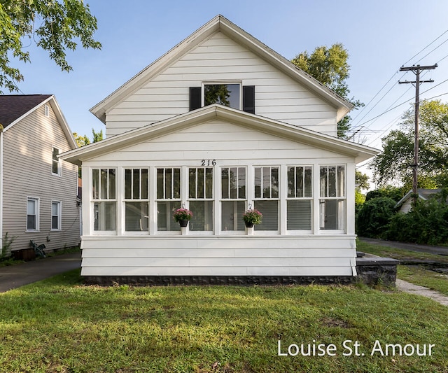 exterior space with a sunroom and a front lawn