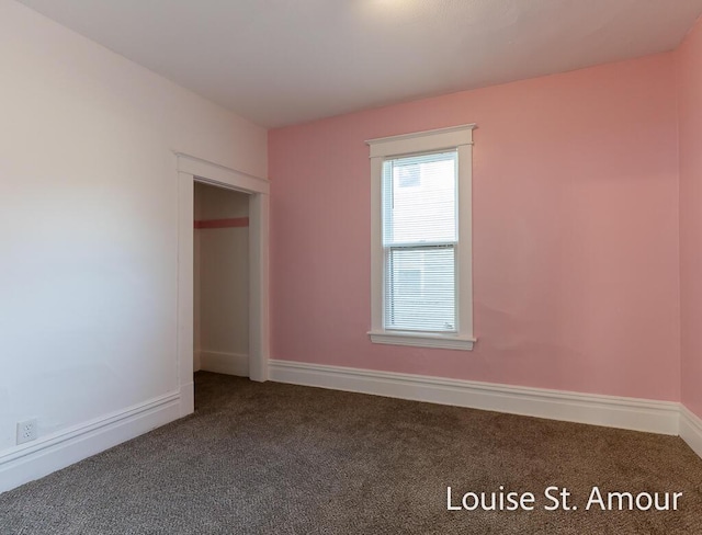 unfurnished bedroom featuring dark colored carpet and baseboards