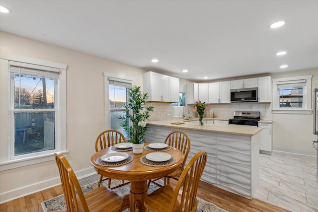 dining space with light hardwood / wood-style floors and sink