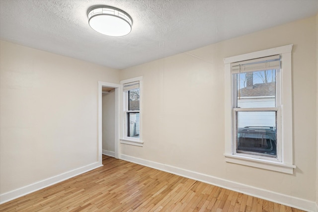 empty room featuring light hardwood / wood-style floors and a textured ceiling