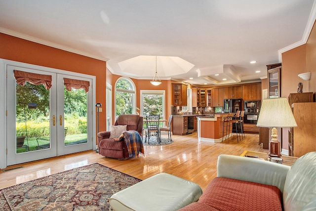 living room with light wood-style flooring, recessed lighting, visible vents, ornamental molding, and french doors