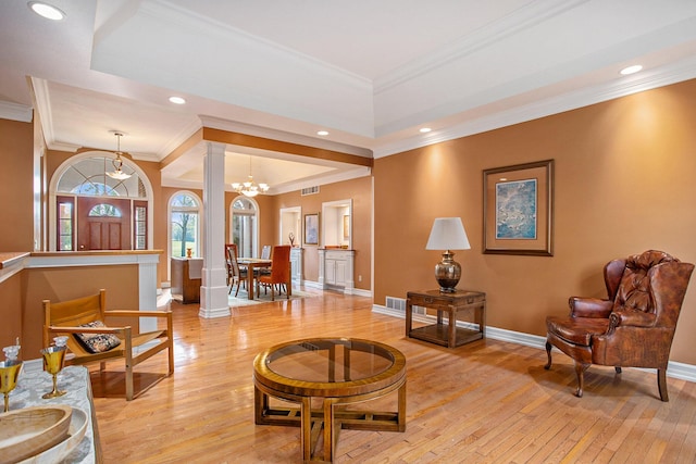 living room with ornamental molding, light wood-type flooring, ornate columns, and baseboards