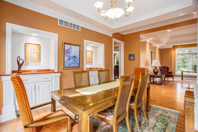 dining area with light wood-style floors, visible vents, a notable chandelier, and ornamental molding