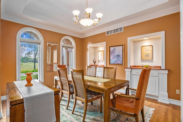 dining space with baseboards, light wood-style flooring, visible vents, and an inviting chandelier