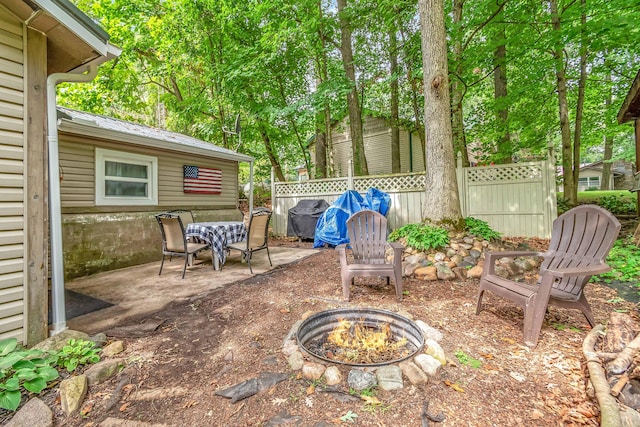 view of patio / terrace with fence, a fire pit, and area for grilling