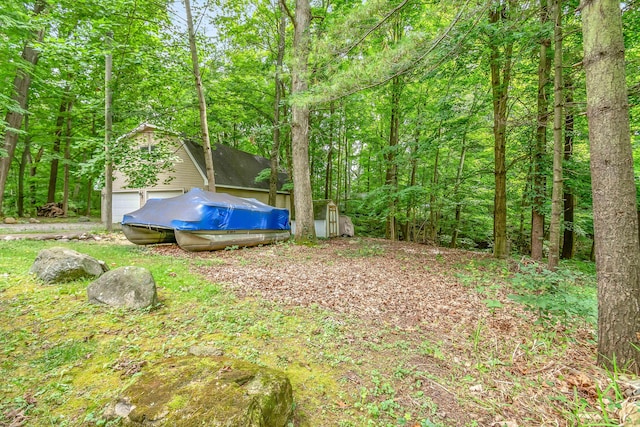 view of yard featuring a view of trees and an outdoor structure