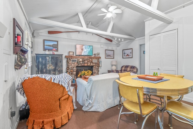 living room with ceiling fan, vaulted ceiling with beams, and a fireplace