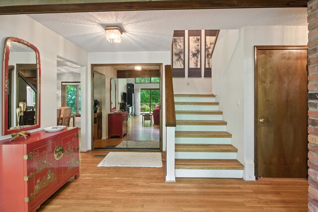 6710 Curtis Rd, Plymouth, MI 48170 - entrance foyer with stairs, light wood-style flooring, and a textured ceiling
