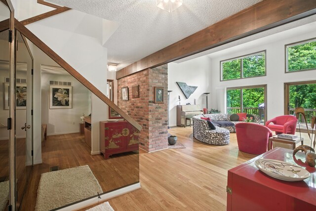 6710 Curtis Rd, Plymouth, MI 48170 - living room with wood finished floors, a textured ceiling, stairway, and ornate columns