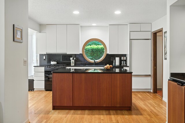 6710 Curtis Rd, Plymouth, MI 48170 - kitchen with modern cabinets, black stove, a kitchen island, white cabinets, and light wood-style floors