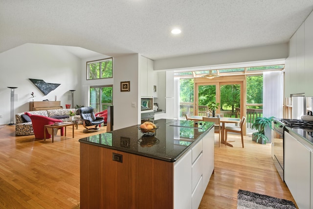 6710 Curtis Rd, Plymouth, MI 48170 - kitchen with stainless steel gas range oven, white cabinets, a textured ceiling, light wood-type flooring, and dark stone countertops