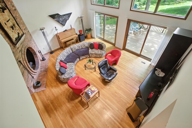 6710 Curtis Rd, Plymouth, MI 48170 - living area with wood finished floors, a high ceiling, and a brick fireplace