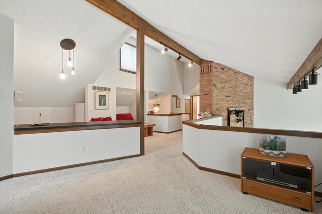 6710 Curtis Rd, Plymouth, MI 48170 - living area featuring carpet flooring, a fireplace, beam ceiling, track lighting, and high vaulted ceiling