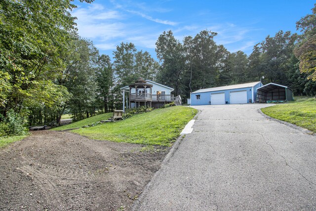 view of front of home with a front lawn, an outdoor structure, and a garage