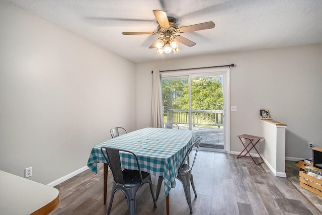 dining area with ceiling fan, a textured ceiling, and dark hardwood / wood-style floors