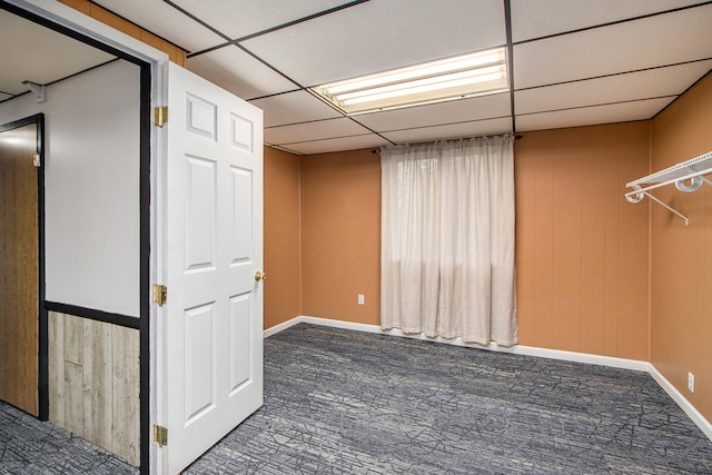 carpeted empty room with a drop ceiling