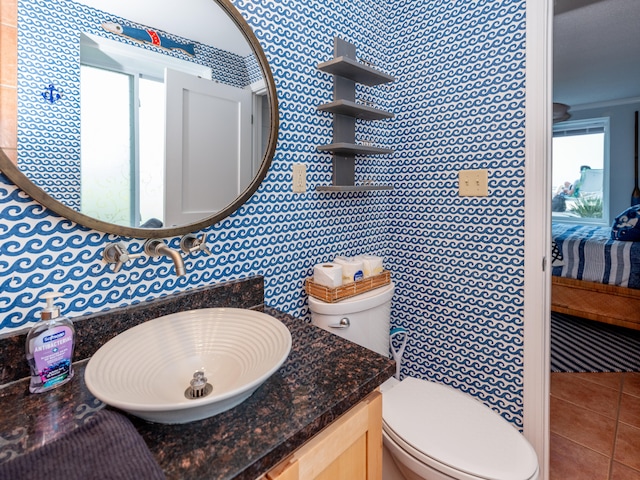 bathroom with vanity, toilet, tile walls, and tile patterned flooring