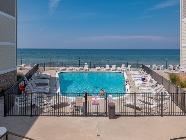 view of swimming pool featuring a patio area and a water view