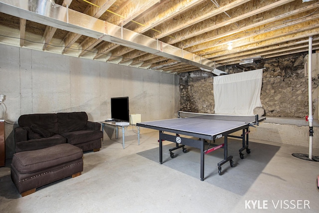 recreation room featuring unfinished concrete floors