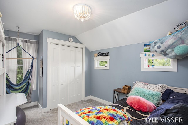 bedroom with light carpet, a closet, lofted ceiling, and baseboards