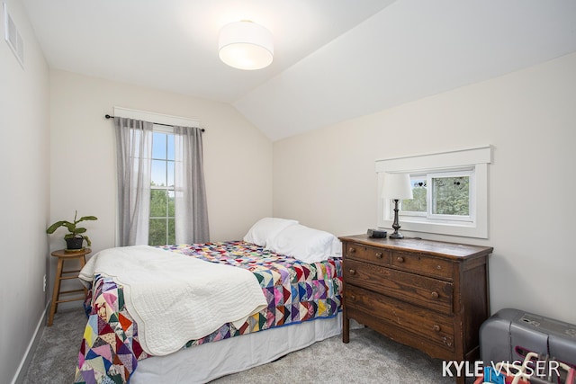 carpeted bedroom featuring lofted ceiling, visible vents, and baseboards