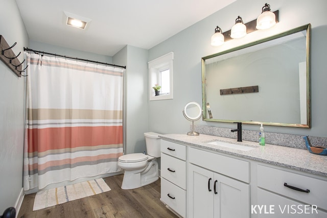 full bath featuring curtained shower, vanity, toilet, and wood finished floors