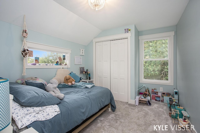 bedroom featuring carpet floors, vaulted ceiling, and a closet