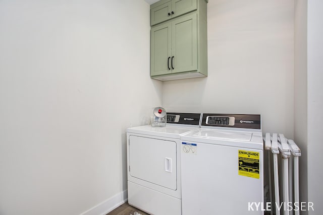 washroom with radiator heating unit, cabinet space, independent washer and dryer, and baseboards