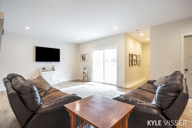 living area featuring baseboards, light wood finished floors, and recessed lighting